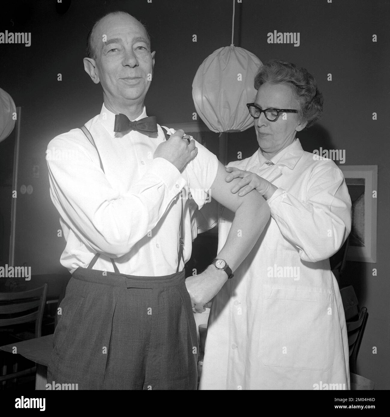 Vaccine in the 1960s. A nurse injects a vaccine in the arm of a man. Sweden 1965 Conard ref 5011 Stock Photo