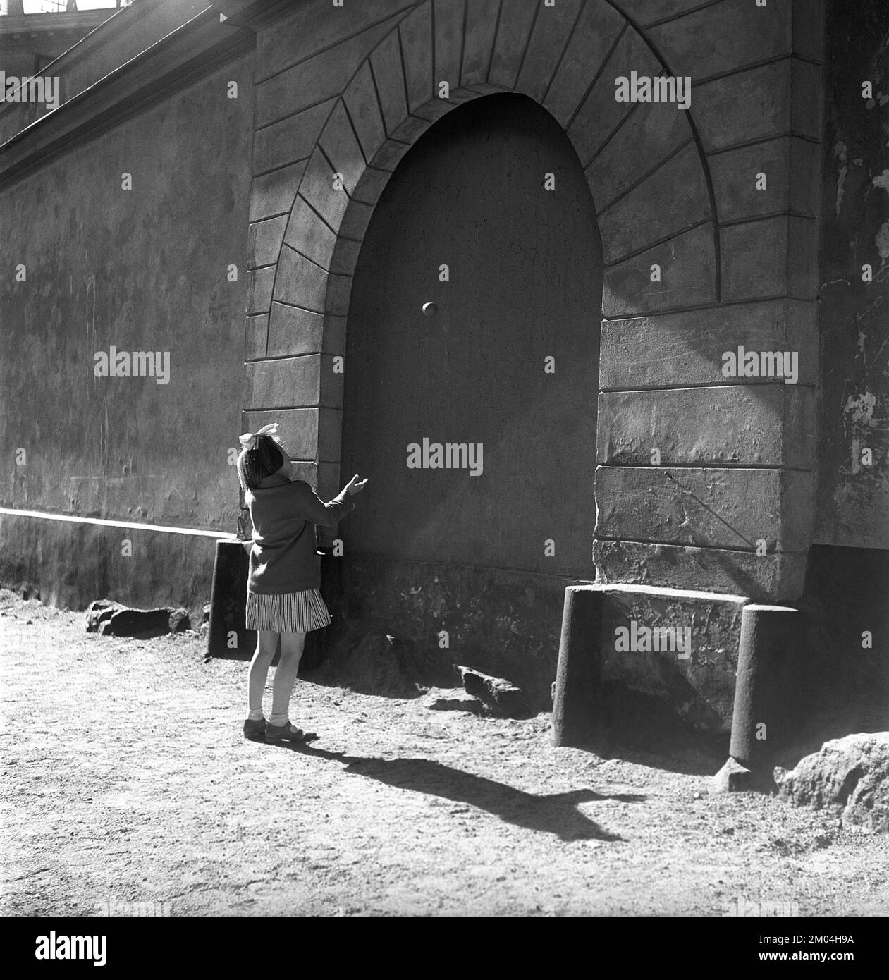 Summer activitiy in the 1950s. A young girl is playing by herself, throwing a ball against the wall. A typical game of where the ball was thrown twelve times against the wall and each throw was made differently. If you lost the ball or it hit the ground, you had to start over again. Fiskargatan 8 Stockholm Sweden Kristoffersson Ref BC47-7 Stock Photo