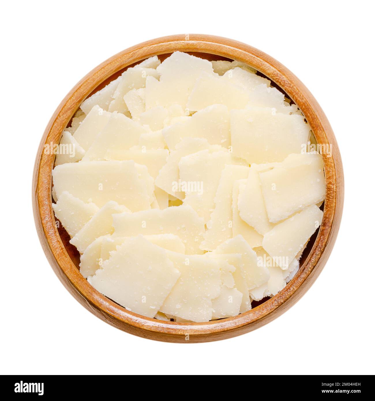 Grana Padano cheese flakes, in a wooden bowl. Italian hard cheese, similar to Parmesan, crumbly-textured, with strong savory flavor and gritty texture. Stock Photo