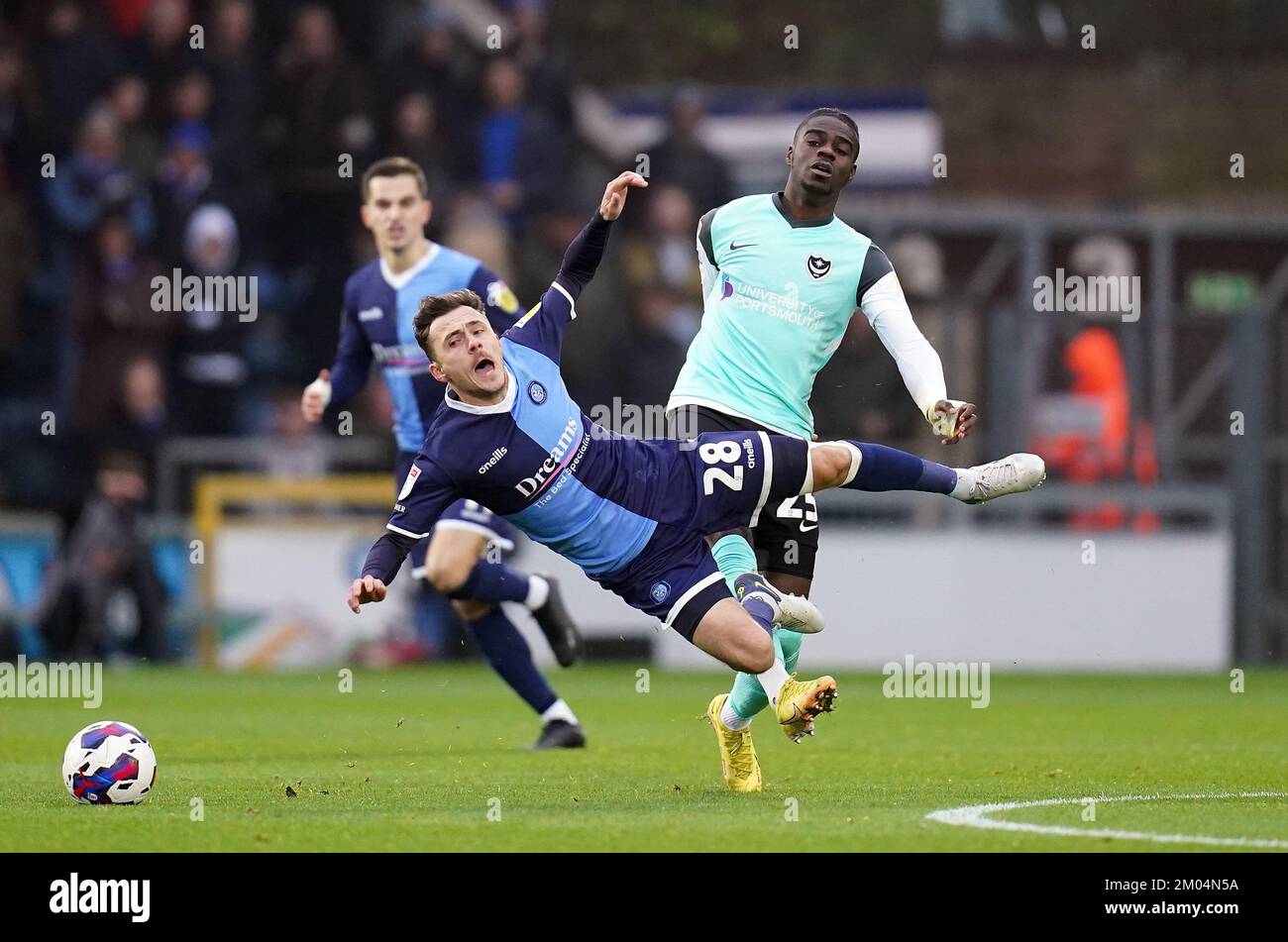 Wycombe Wanderers’ Josh Scowen is fouled by Portsmouth’s Jay Mingi during the Sky Bet League One match at Adams Park, Wycombe. Picture date: Sunday December 4, 2022. Stock Photo