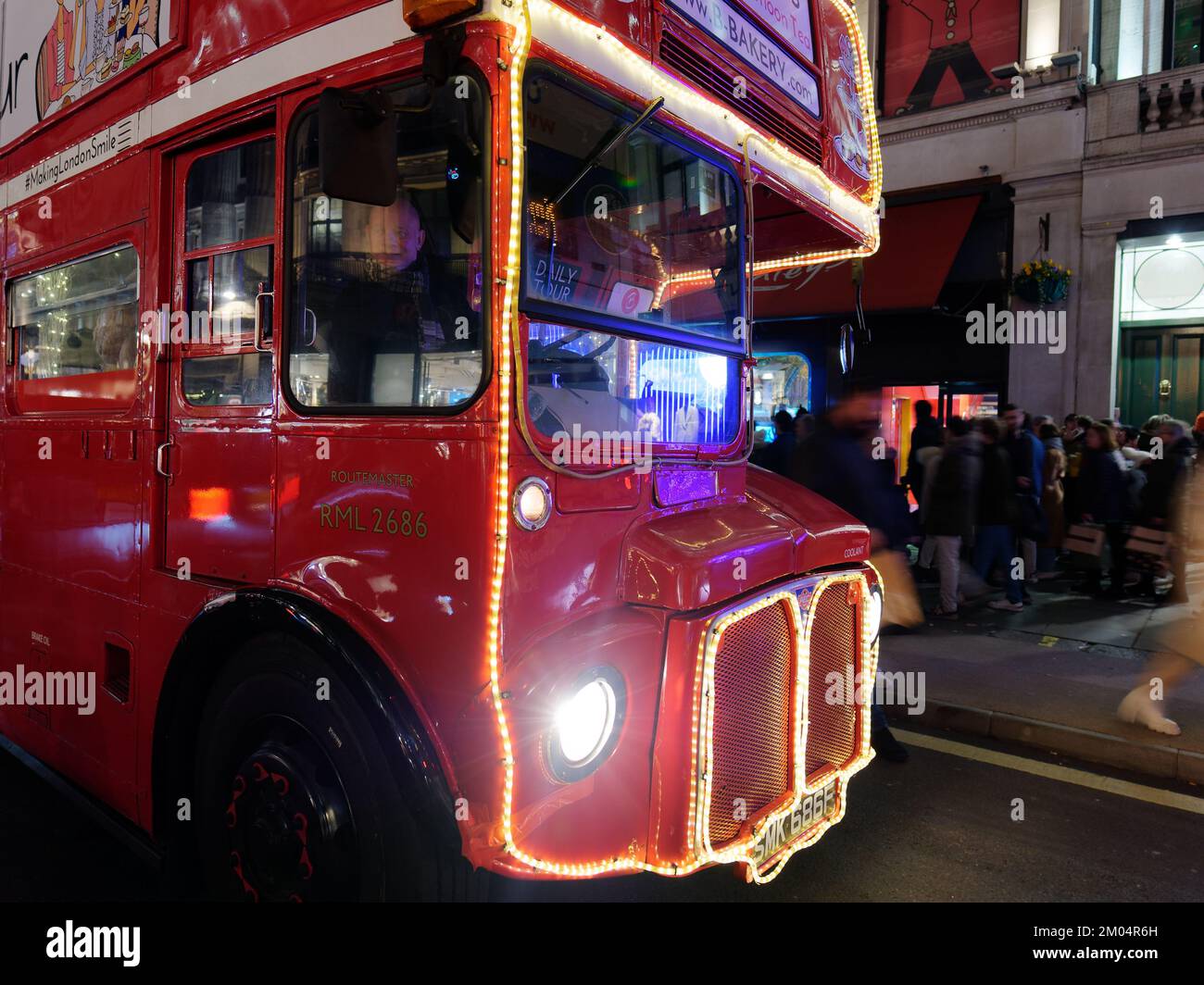 Bus on Regent Street with Christmas Light Display as pedestrians are blurred by movement, London at night. Stock Photo