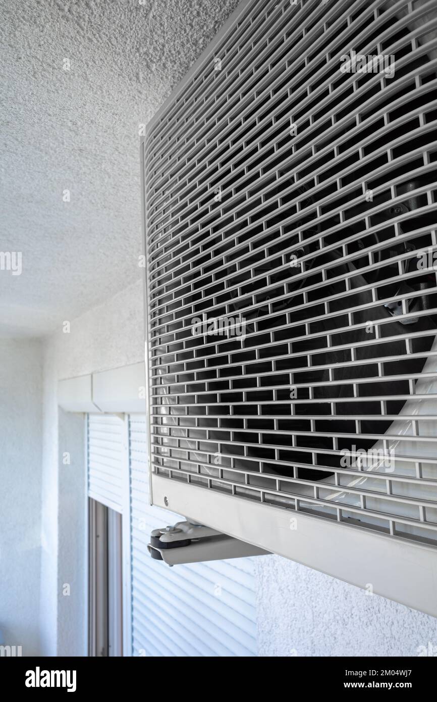 Front grill of wall mounted air conditioner on the balcony of the apartment building. Stock Photo