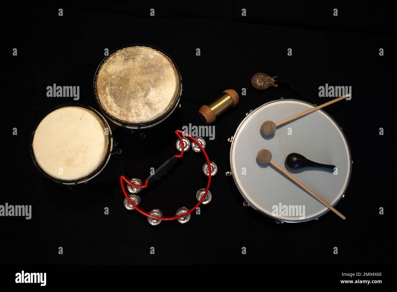A group of percussion instruments including, drum, stick, shaker