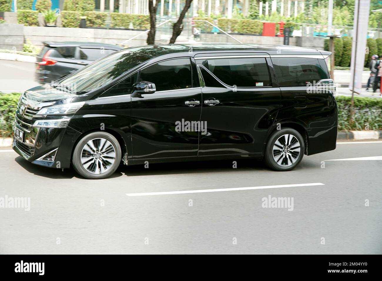 Luxury car Toyota Alphard on the street, in comercial district area