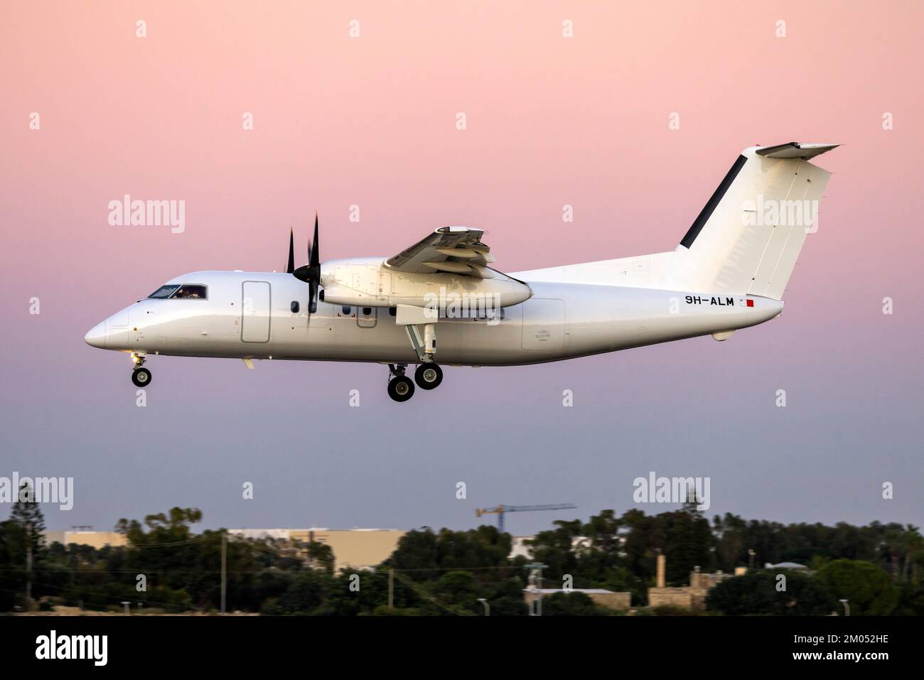 Air CM Global De Havilland Canada DHC-8-103 Dash 8 (REG: 9H-ALM) arriving after sunset from Libya. Stock Photo