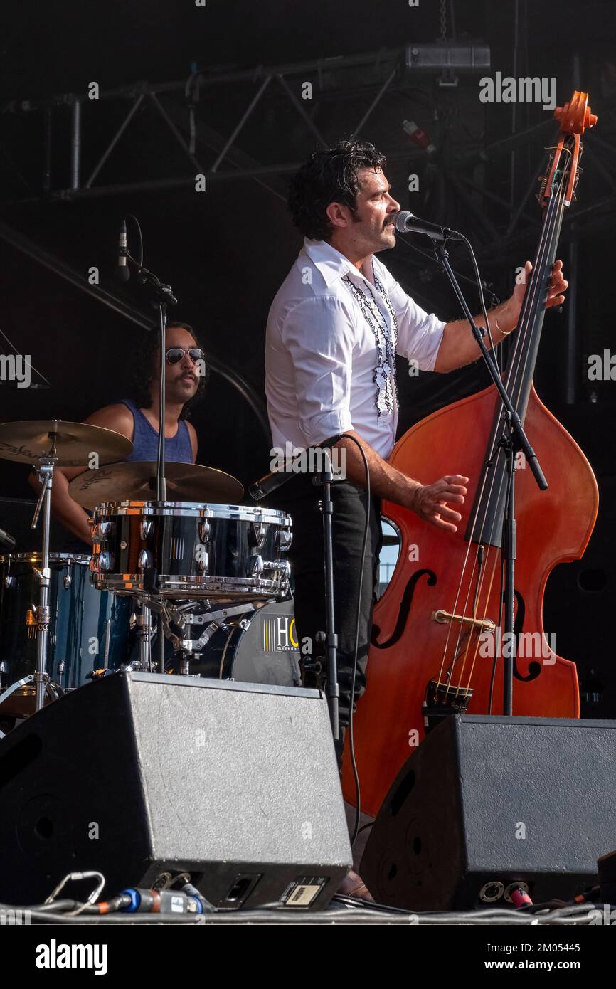 The singer and double bass player of the rockabilly band Johnny Montreuil on stage with the dummer in the background Stock Photo
