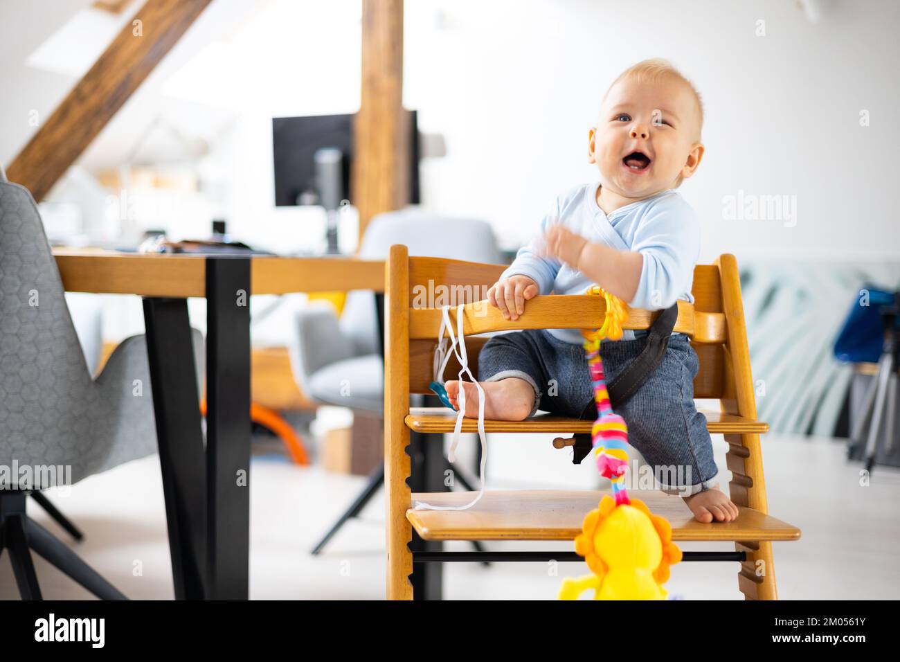 Happy infant sitting and playing with his toy in traditional