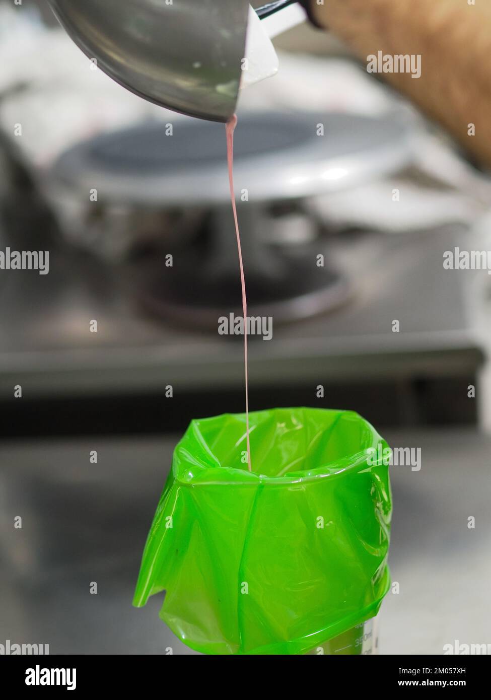pastry chef filling piping bag filling mixed with edible pink paint for