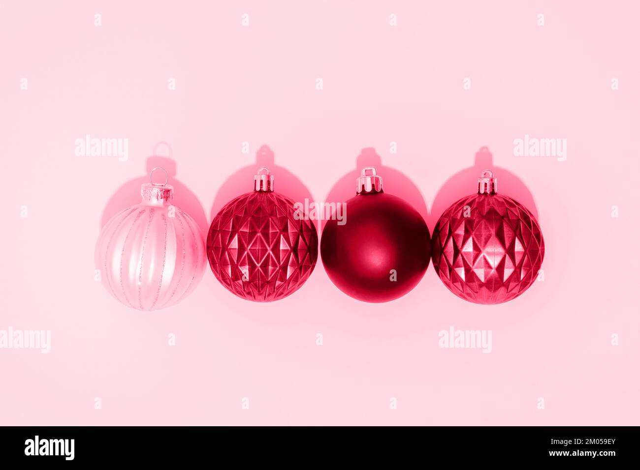 Viva magenta Christmas balls on pink background with sharp shadows. Top ...