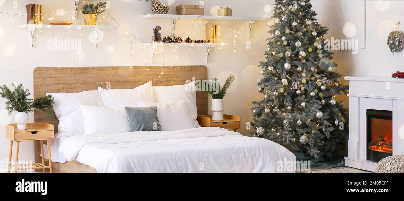 https://c8.alamy.com/comp/2M05CFF/interior-of-light-bedroom-with-christmas-tree-fireplace-and-glowing-lights-2M05CFF.jpg
