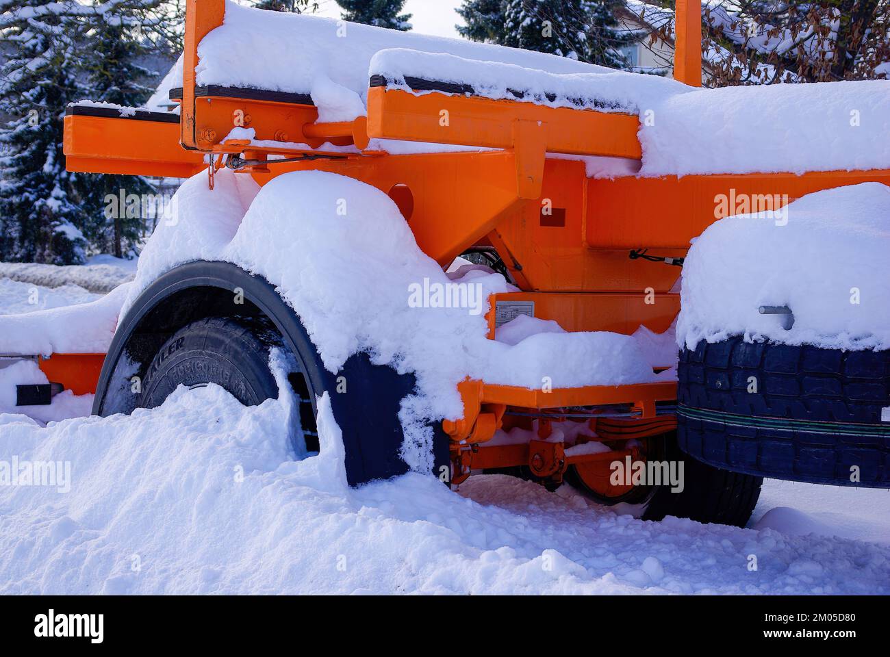 Snow-covered low loader or articulated lorry with a wheel stuck in the snow in winter. Stock Photo