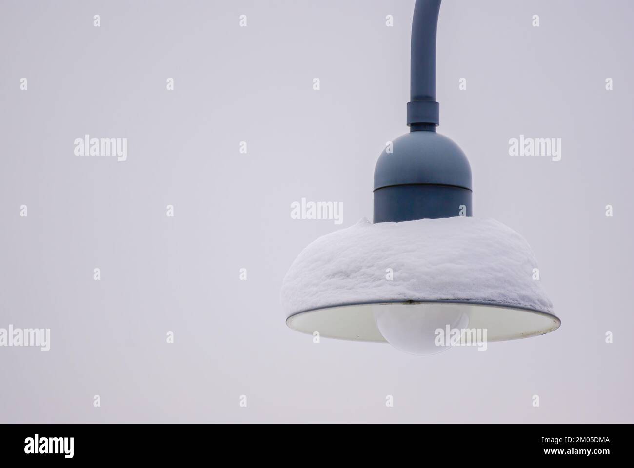 Snow-covered lamp of a public streetlight. Stock Photo