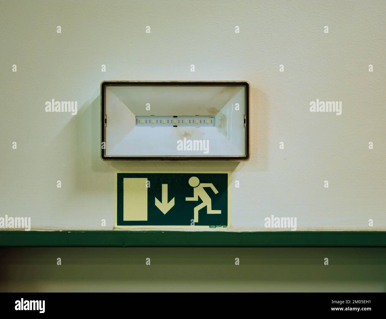 Emergency Fire Exit Light Sign above door for escape, arrow of run