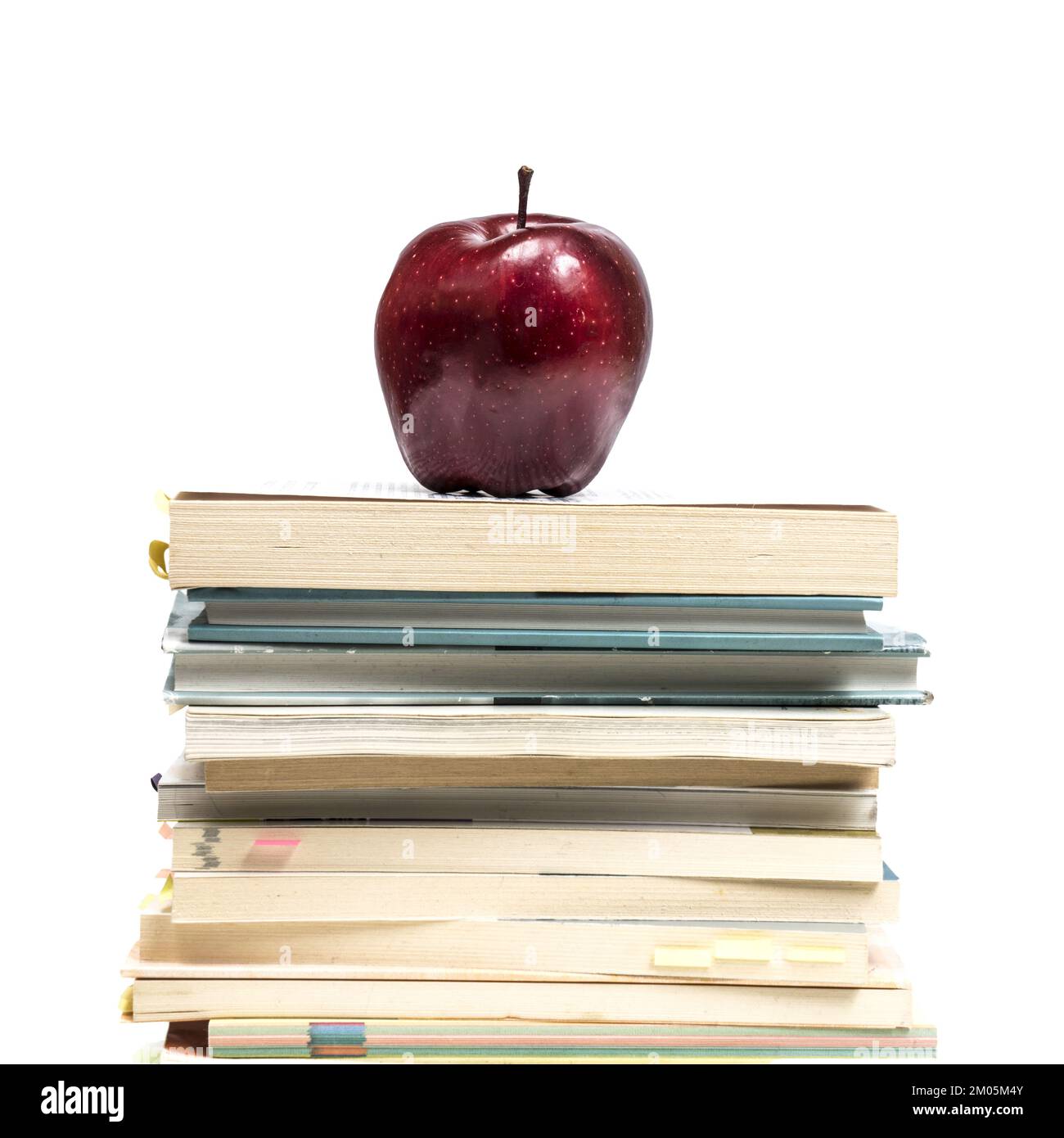 a red apple on top of a pile of books Stock Photo