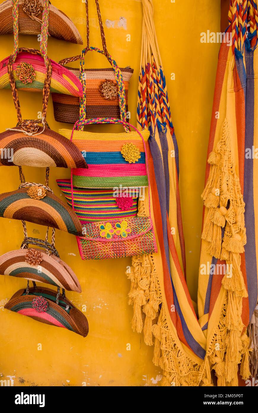 Colorful handicrafts on yellow wall at Cartagena's street market, Colombia Stock Photo