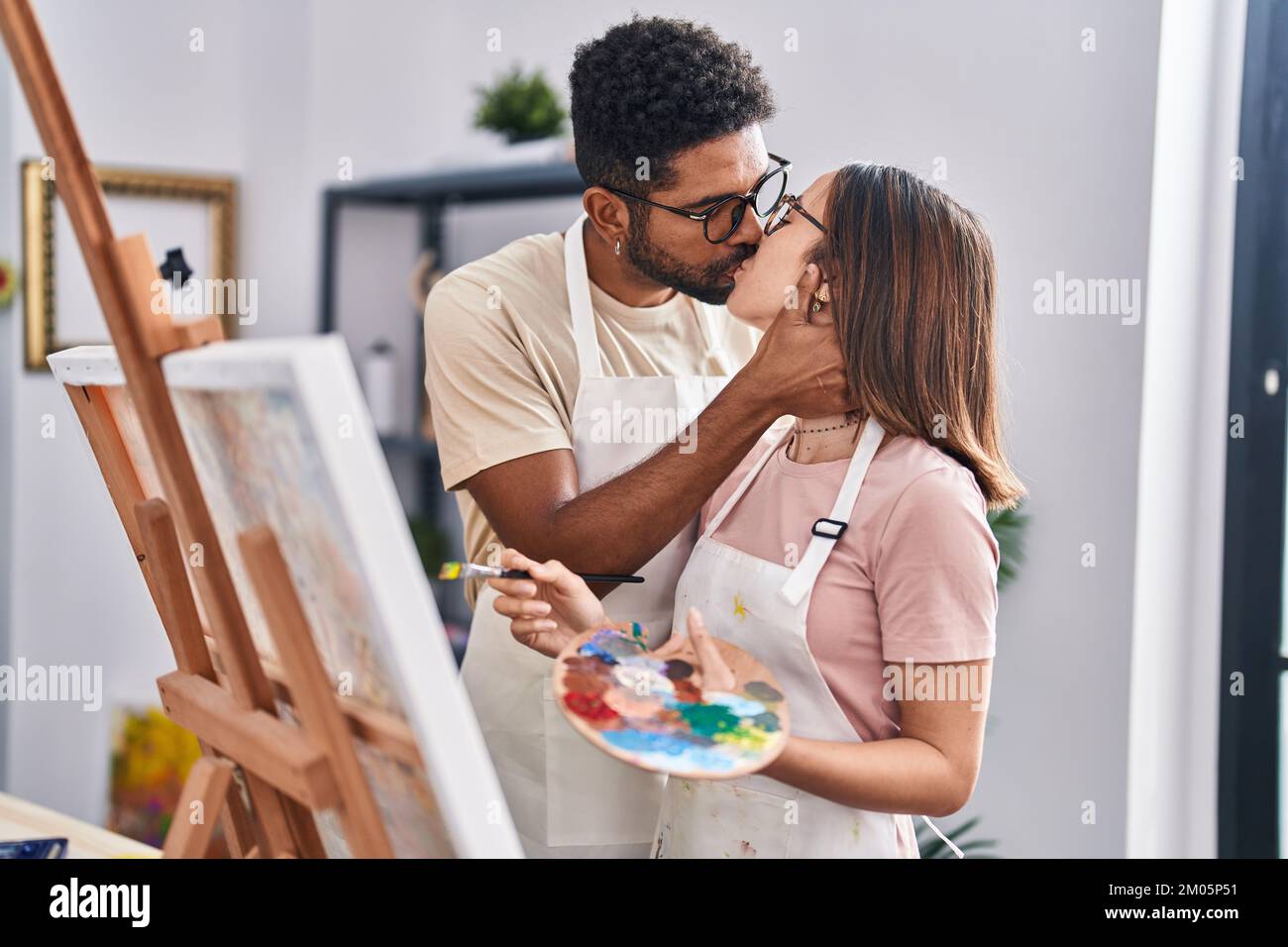 Man and woman couple drawing and kissing at art studio Stock Photo - Alamy