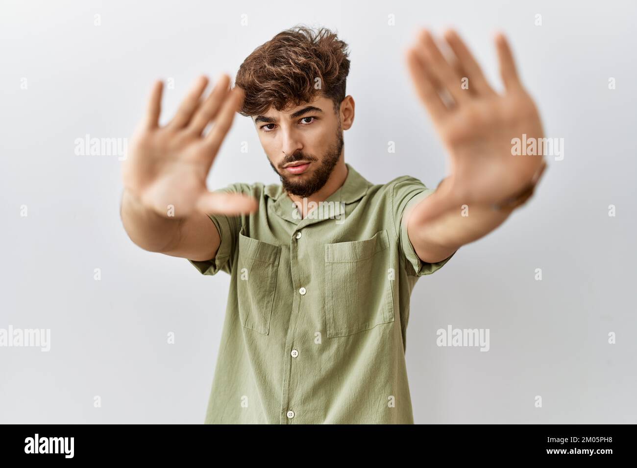 Young arab doctor man standing over isolated background doing frame using hands palms and fingers, camera perspective Stock Photo