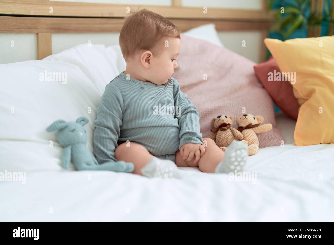 Adorable toddler sitting on bed with dolls at bedroom Stock Photo - Alamy