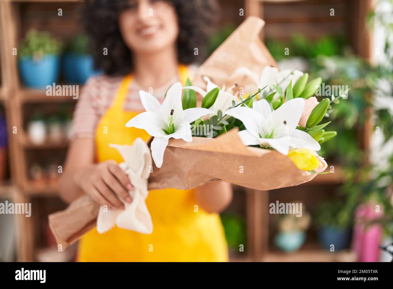 Young middle eastern woman florist holding bouquet of flowers at ...