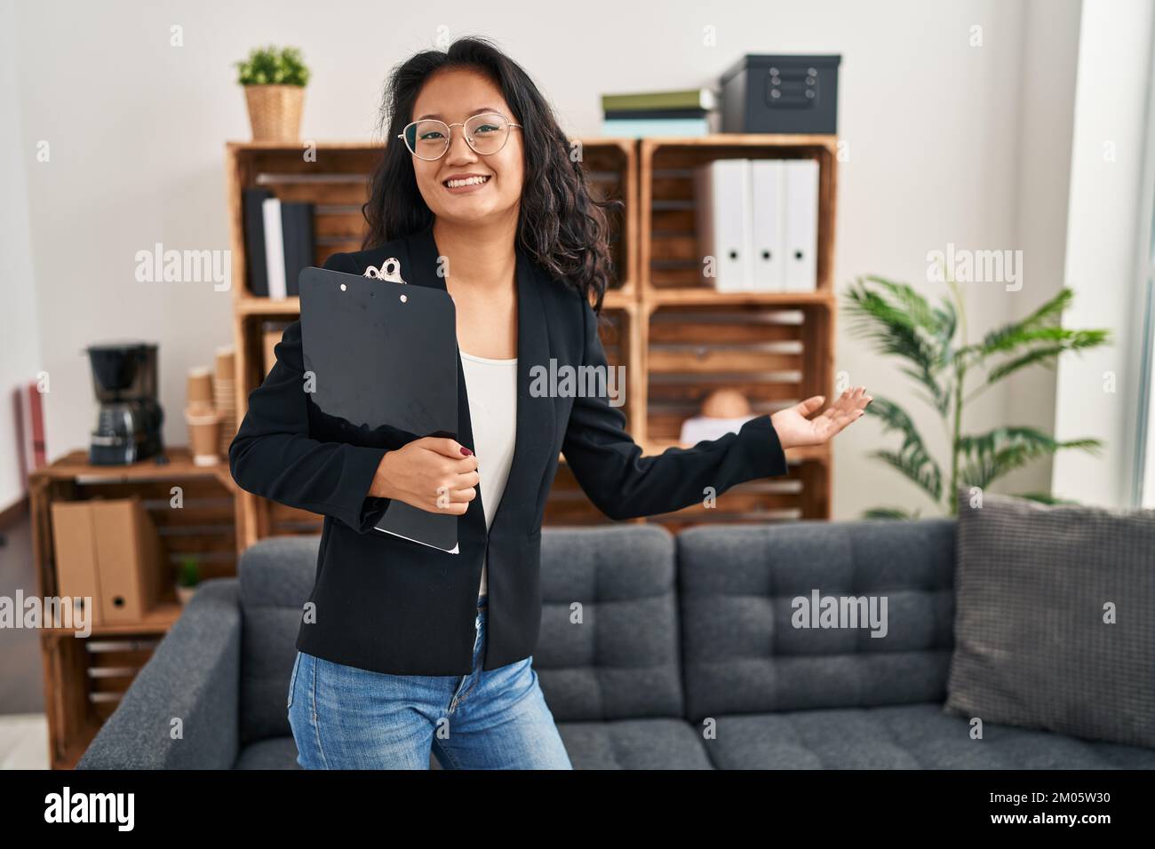 Young chinese woman psychologist holding clipboard standing at clinic Stock Photo Alamy