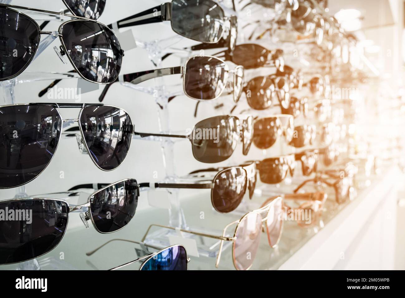 Sunglasses on display shelves in glasses store Stock Photo
