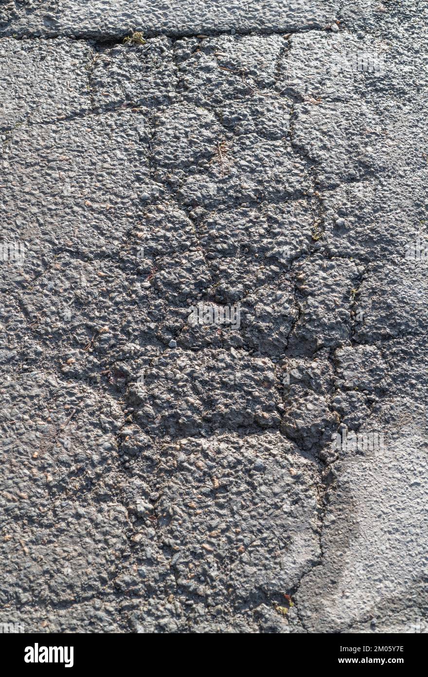 Frost / fatigue damaged tarmac surface with alligator cracking on a rural / country road in UK. For bad highways maintenance, old tarmac, Stock Photo