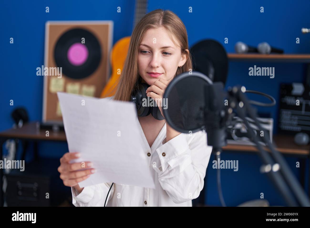 Young caucasian woman artist reading song with doubt expression at ...