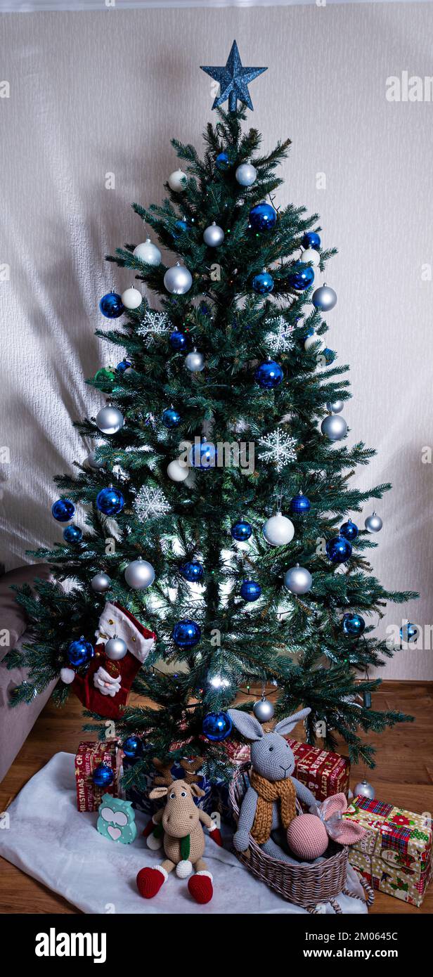 christmas tree with colorful balls and gift boxes over white brick wall ...