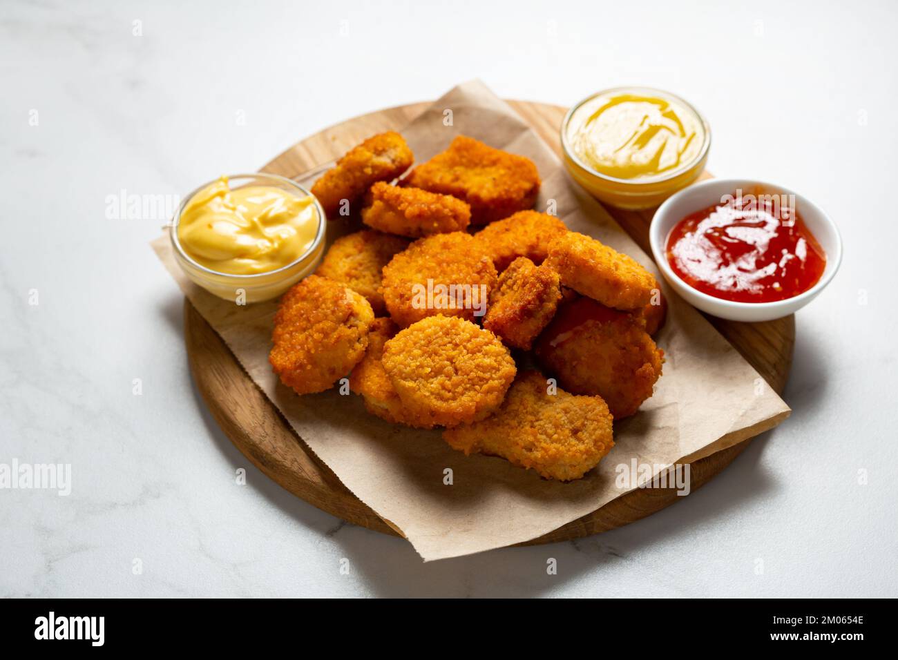Close up of crisp nuggets on wooden fast food and three dips Stock Photo