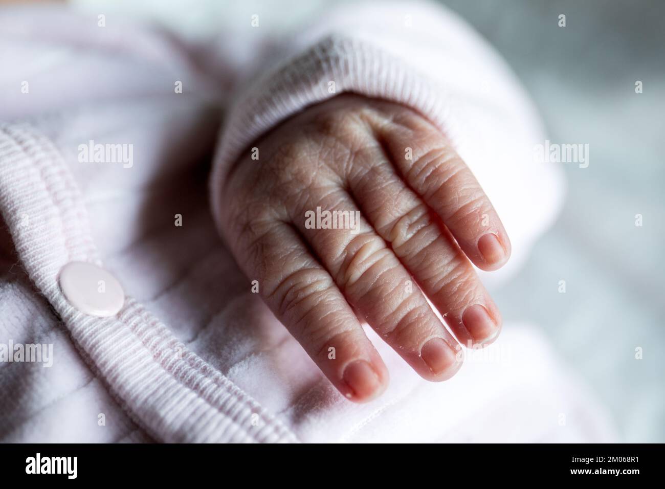 Newborn's hand. fingers, nails and peeling dry skin. Stock Photo
