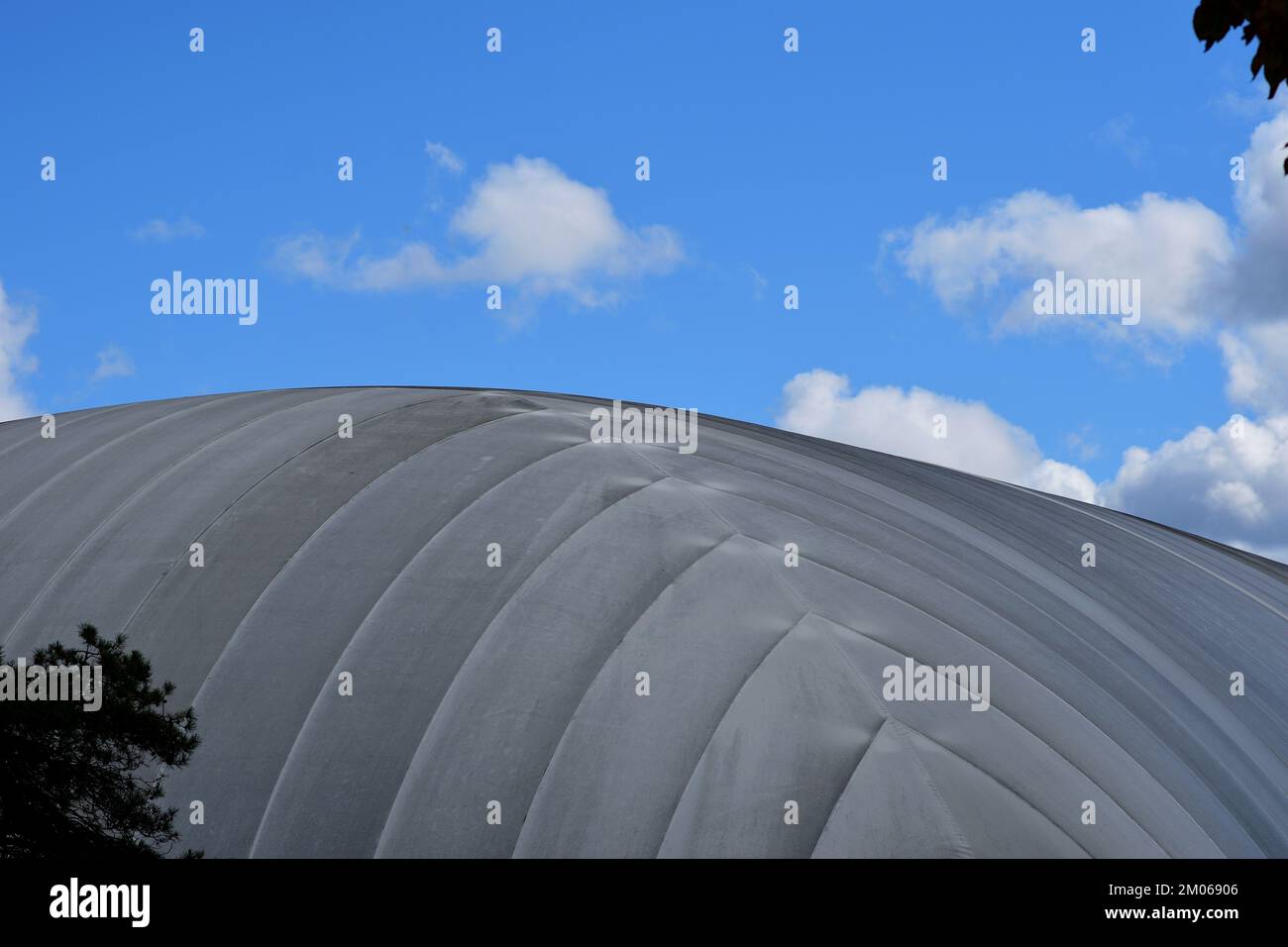 Air-supported seasonal tennis court grey dome against a blue sky. Stock Photo