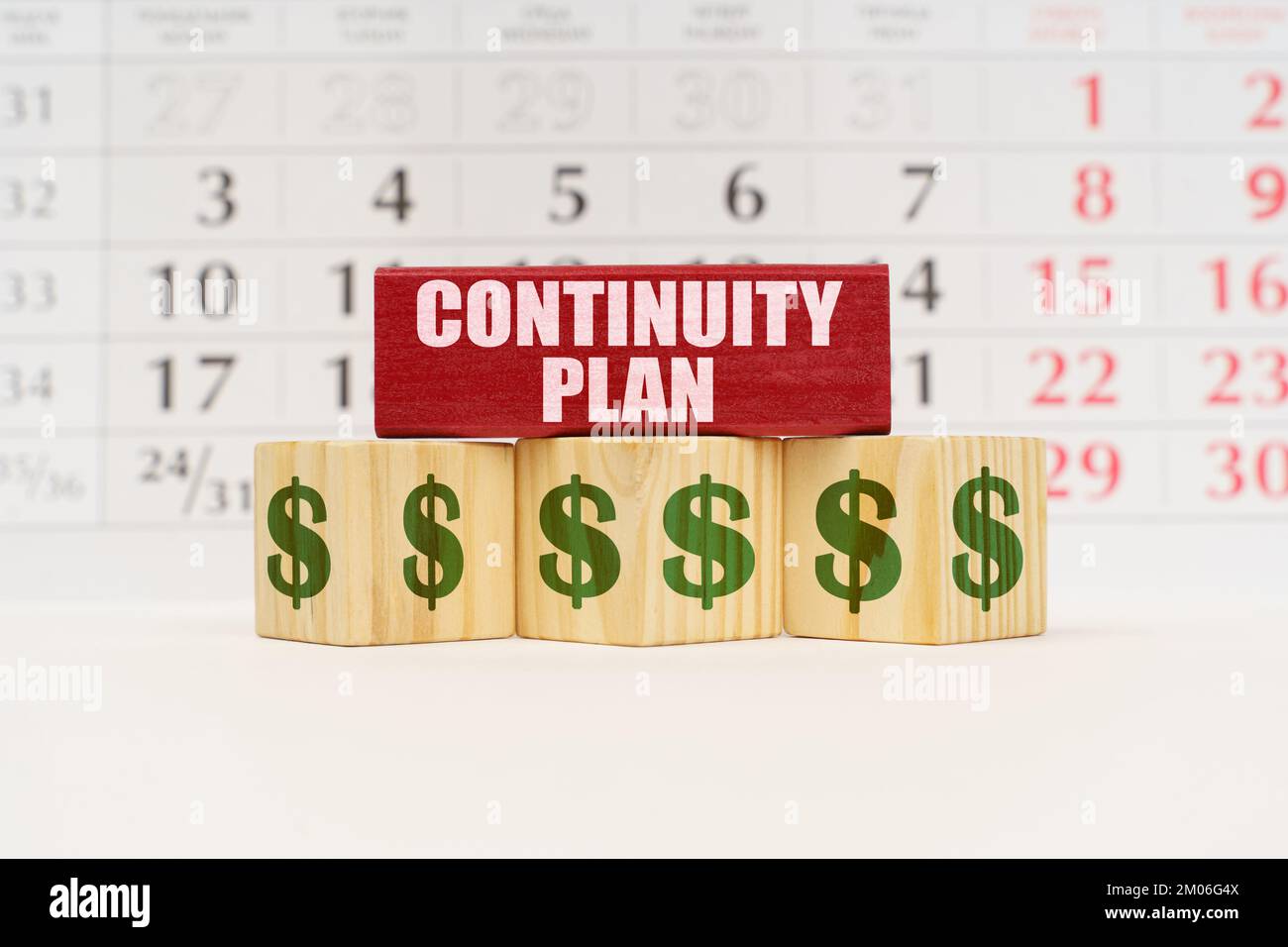 Business planning concept. Against the background of the calendar there are cubes with the image of the dollar and a red plate with the inscription - Stock Photo