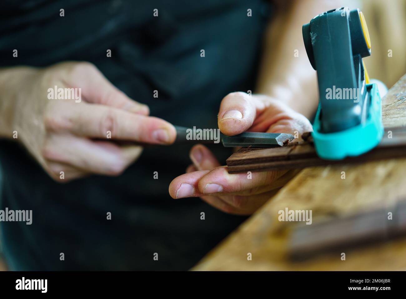 Unrecognizable luthier crafting guitar part Stock Photo