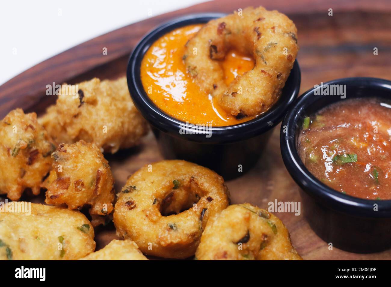 traditional indian snack food, crispy deep fried vada and chutneys in a
