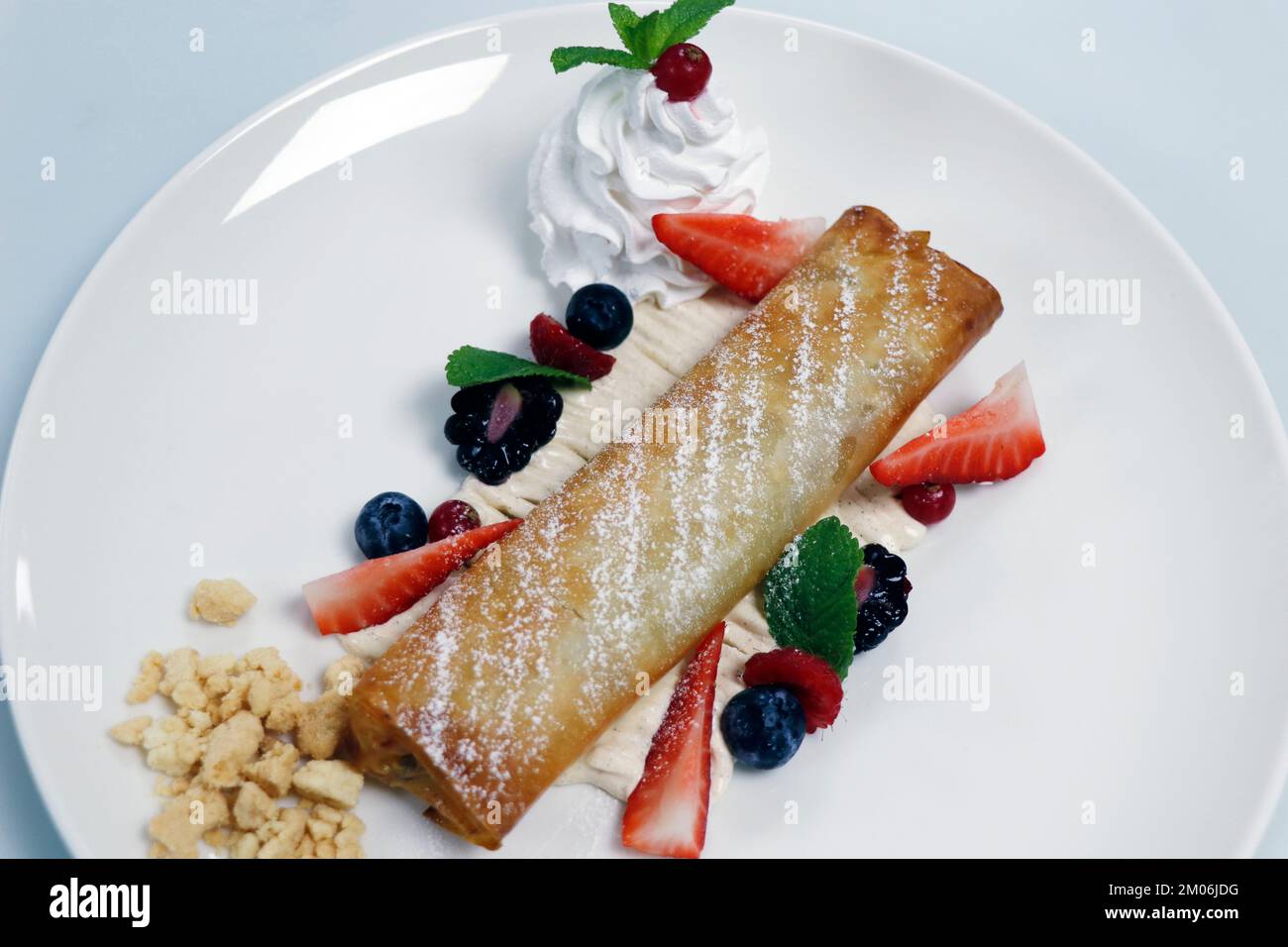 traditional apple strudel with whip cream and fresh mix berries Stock Photo