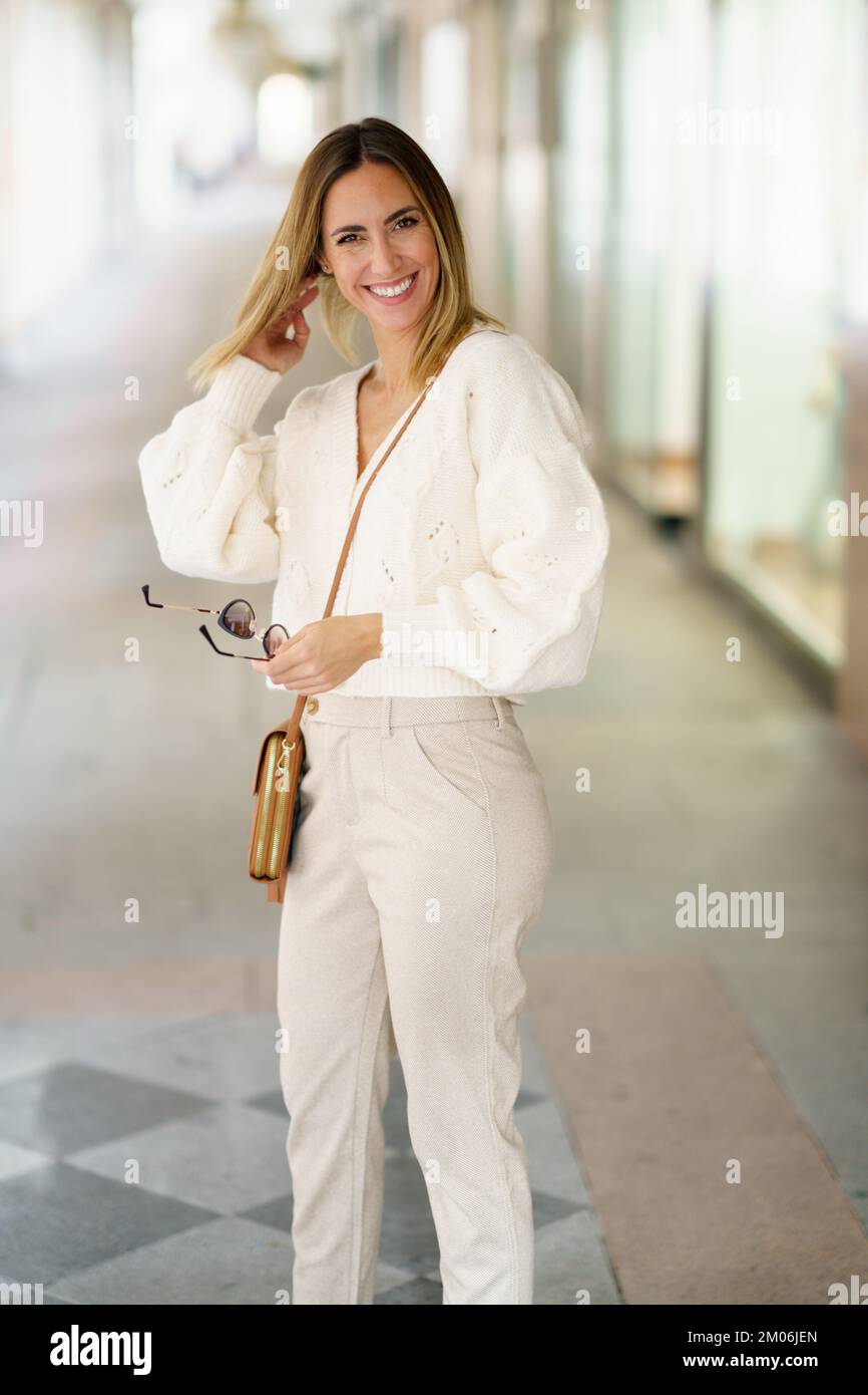 Smiling woman with sunglasses in beige outfit Stock Photo