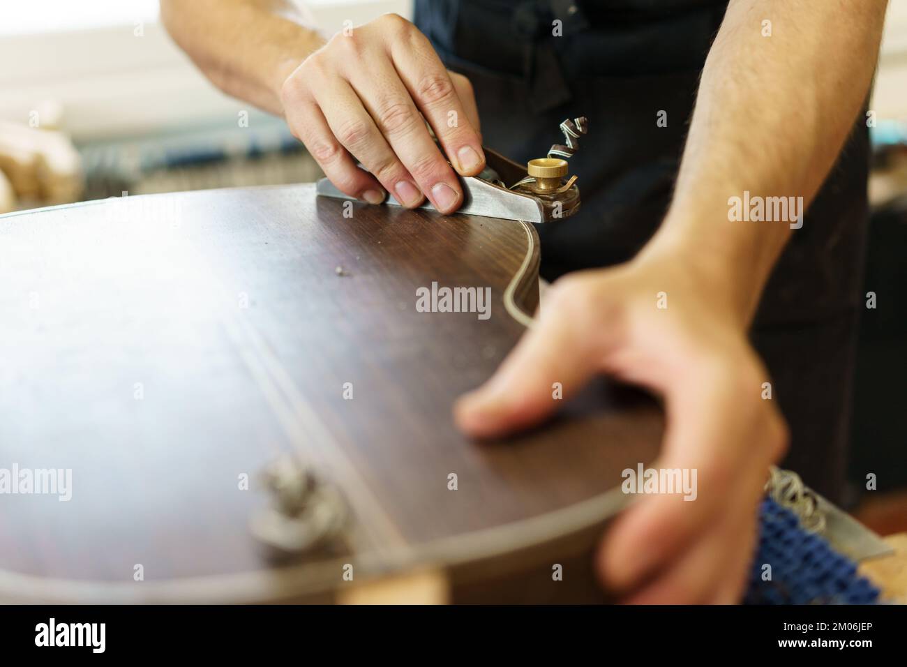 Unrecognizable male luthier crafting Spanish flamenco guitar Stock Photo