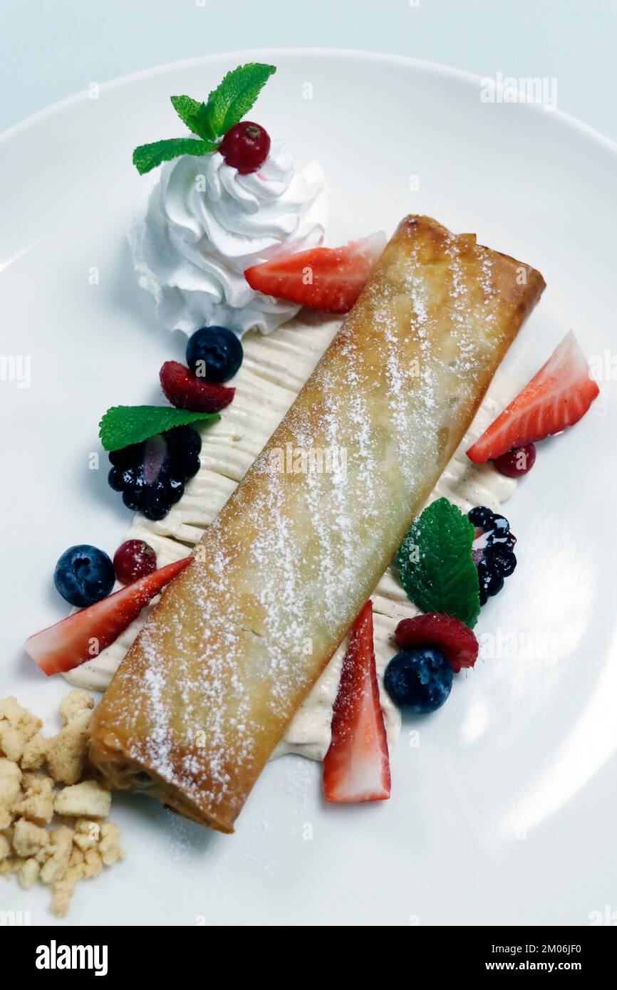 traditional apple strudel with whiped cream and fresh mix berries Stock Photo