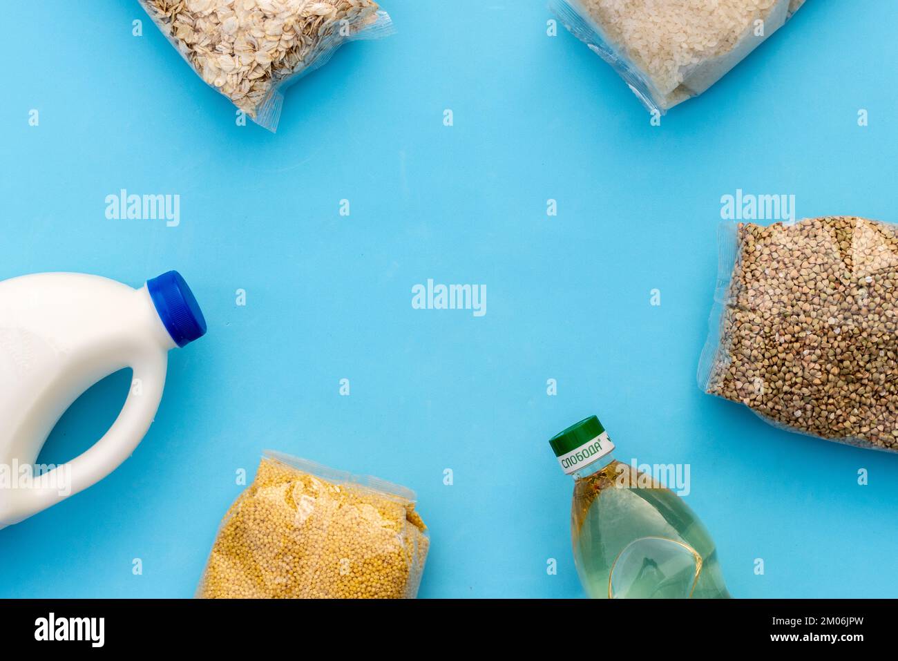 Food supply. Raw porridge, cereals, milk and vegetable oil on the blue