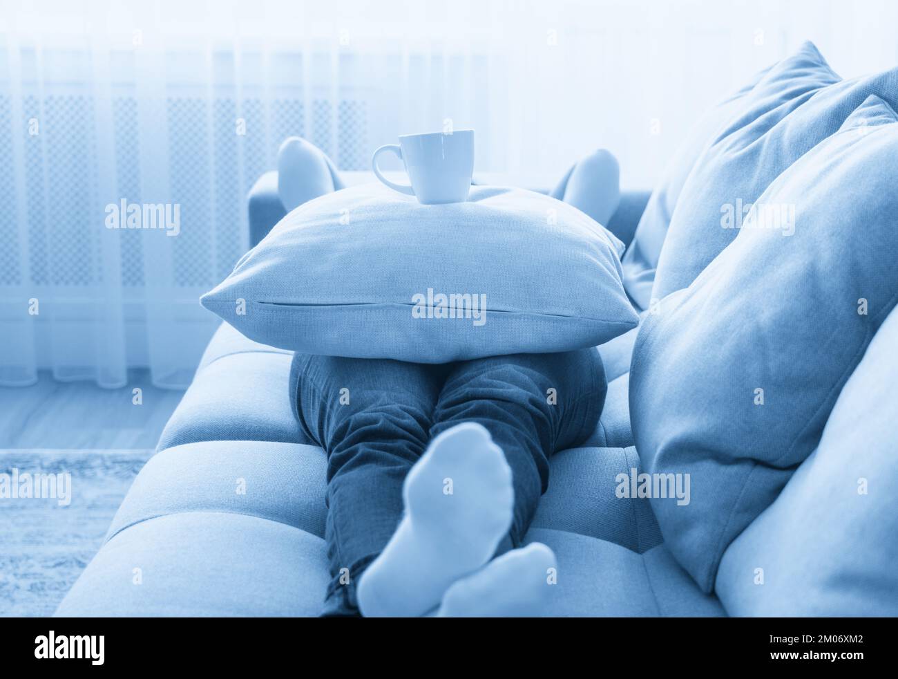 Young woman relaxing on her couch with cup of coffee on a pillow Stock ...