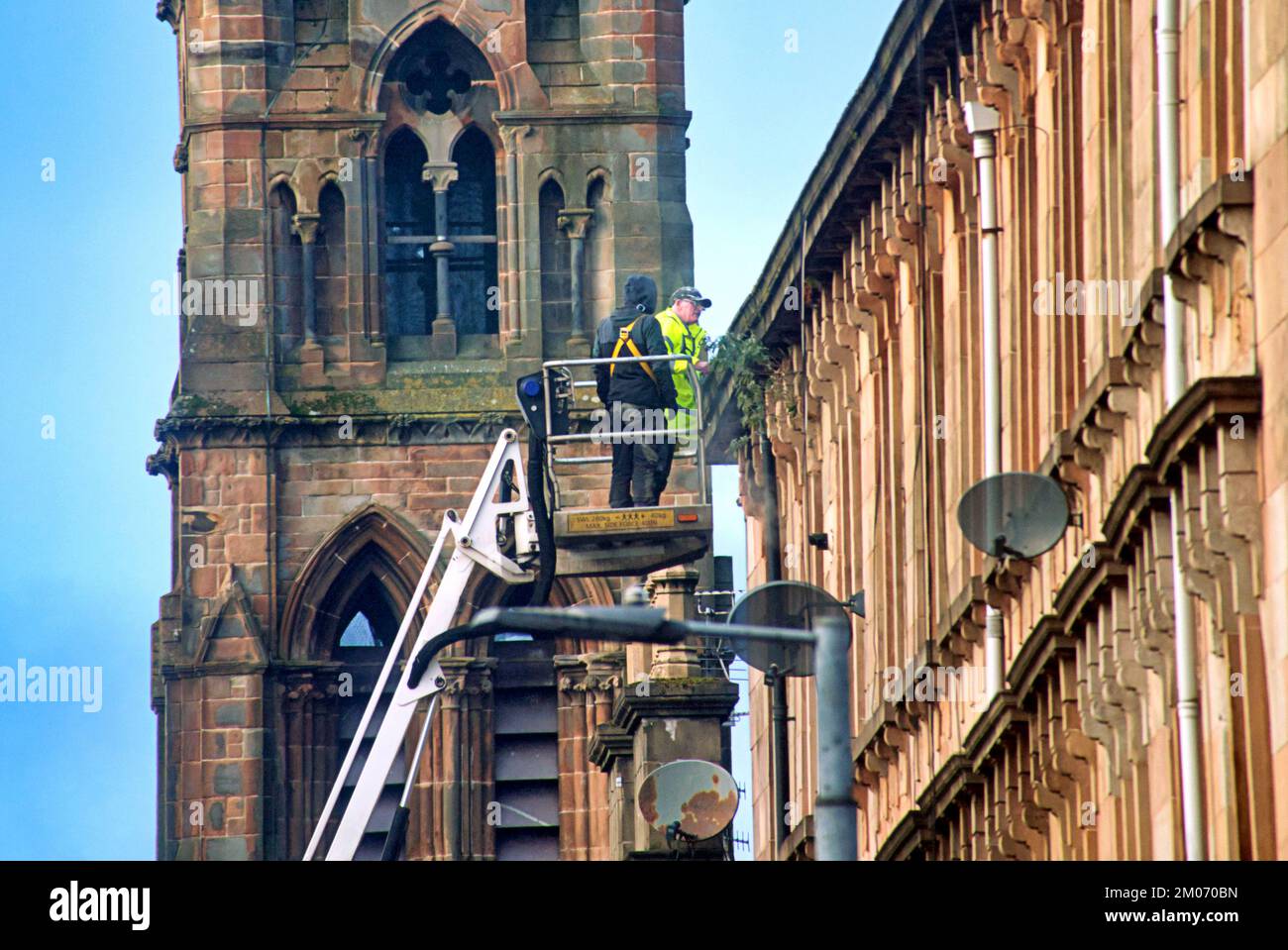workers repairing roof and gutters off tenement great western road Stock Photo