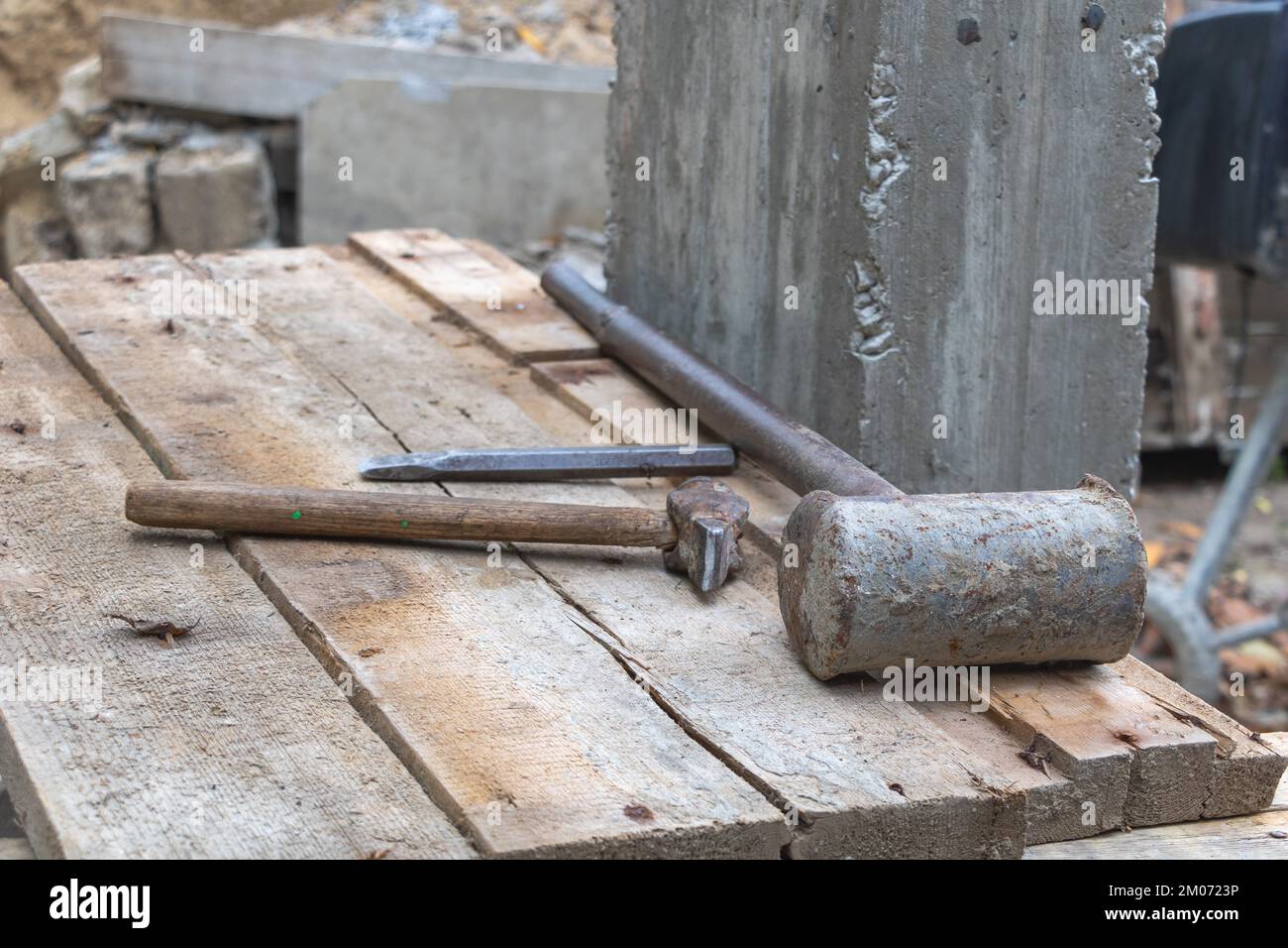 A chisel and two hammers on the work table in the construction site - Construction concept Stock Photo