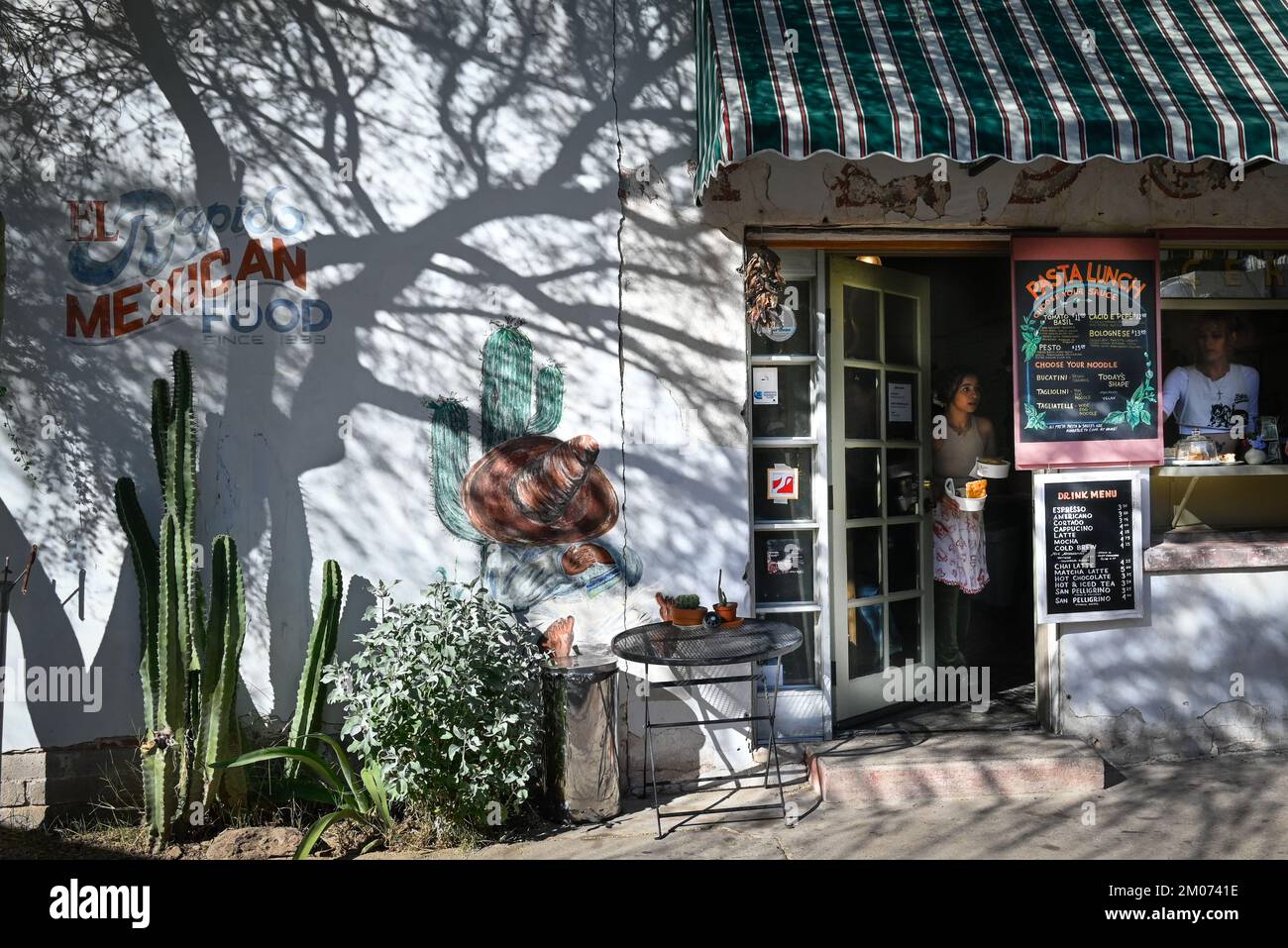 Waitresses ready pasta lunches for patrons on patio enjoying a downtown historic area's trendy