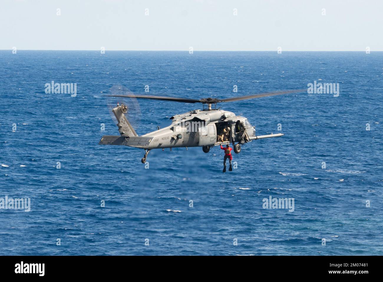 33rd Rescue Squadron crew members hoist a pararescueman assigned to the 31st RS into a HH-60 Pave Hawk over the Pacific Ocean, Nov. 22, 2022. The 33rd RQS conducts extensive training in various rescue scenarios to ensure they are ready to effectively respond to real-world contingencies. (U.S. Air Force photo by Senior Airman Cesar J. Navarro) Stock Photo