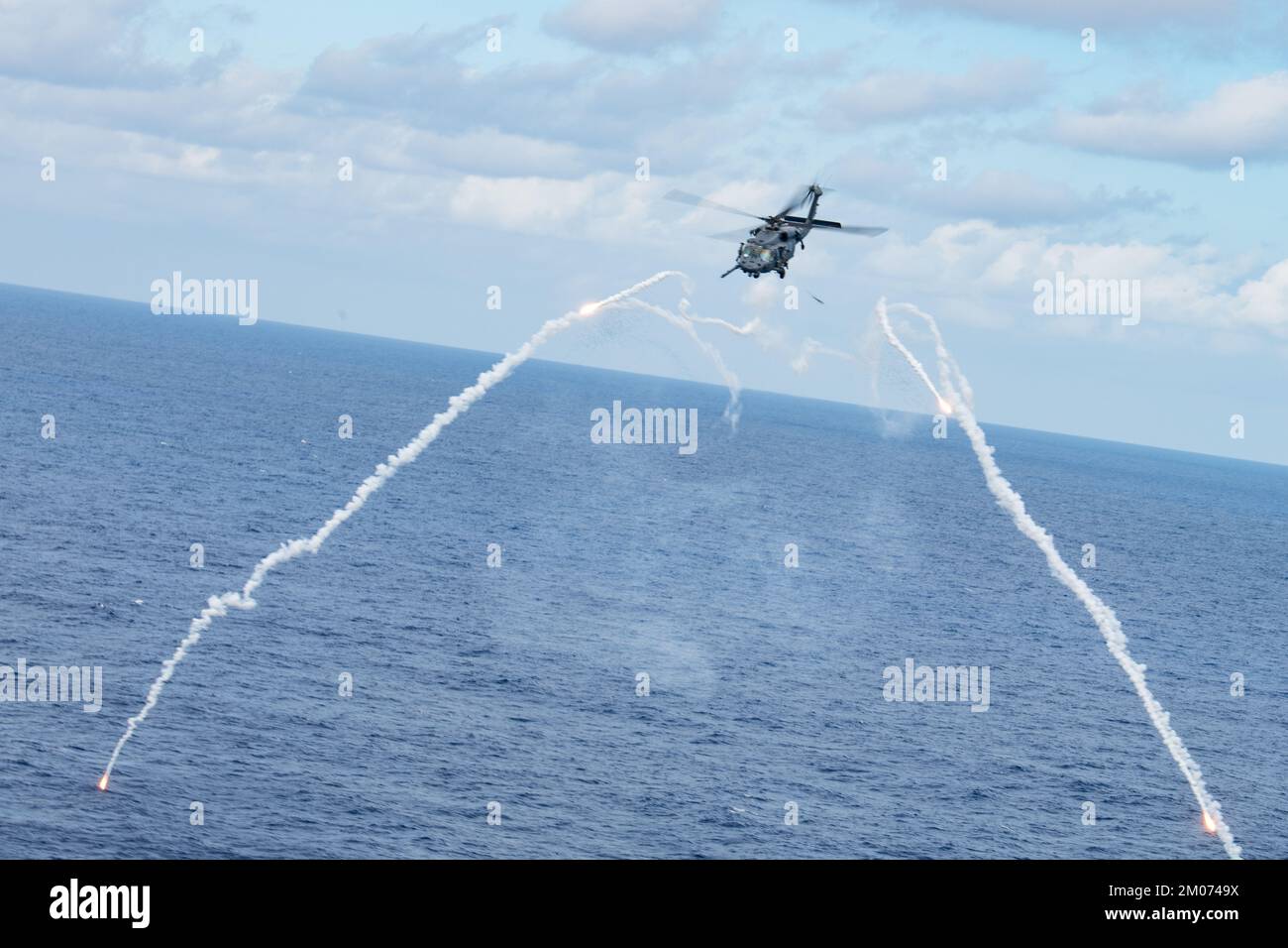 An HH-60 Pave Hawk from the 33rd Rescue Squadron shoots flares while conducting evasive maneuvers in a designated training area over the Pacific Ocean, Nov. 22, 2022. The 33rd RQS maintains readiness for mobilization, deployment and employment of helicopters and rescue of U.S. and allied military members, and civilian personnel. (U.S. Air Force photo by Senior Airman Cesar J. Navarro) Stock Photo