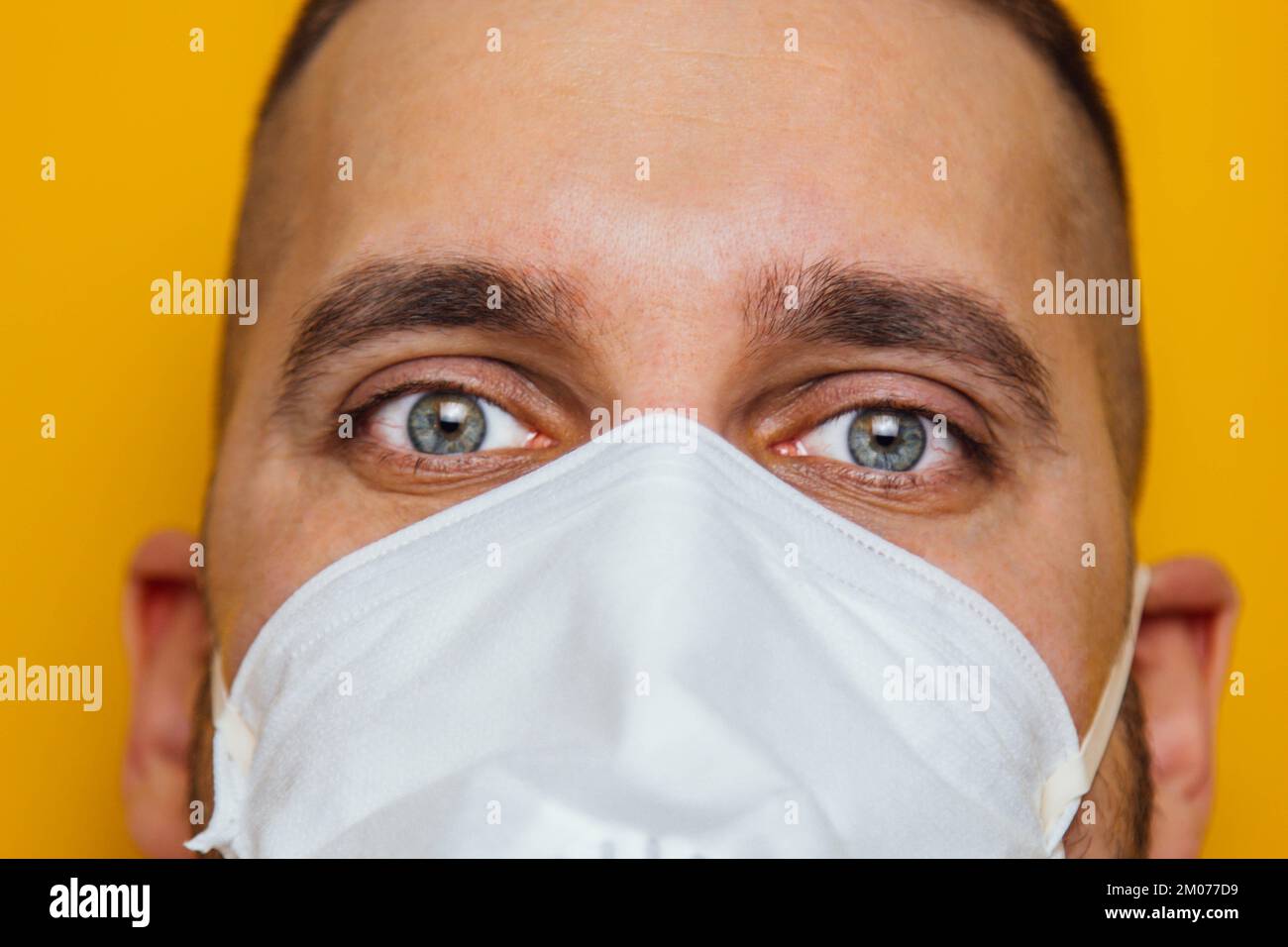Corona virus. Young guy in a respirator on a yellow background