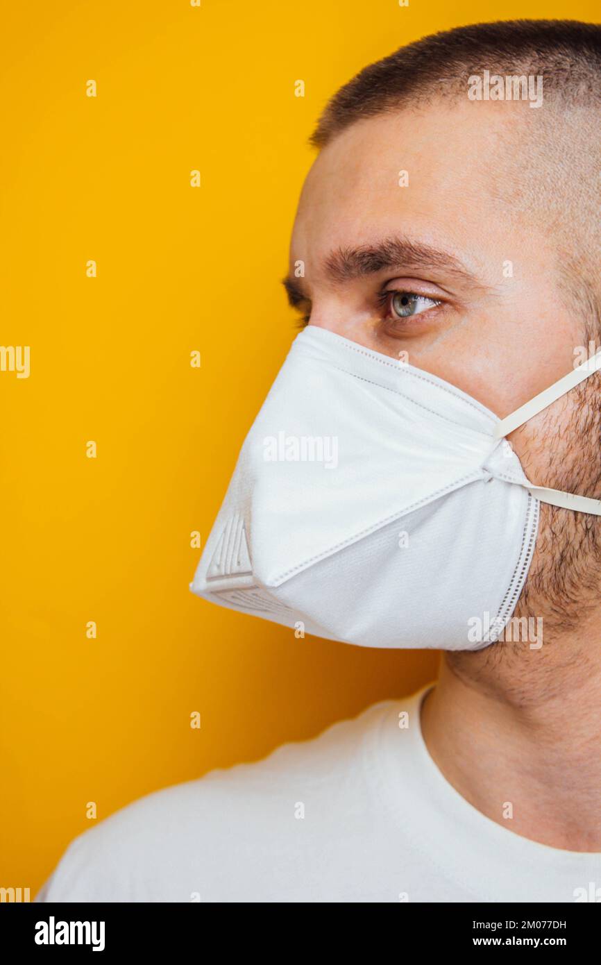 Corona virus. Young guy in a respirator on a yellow background