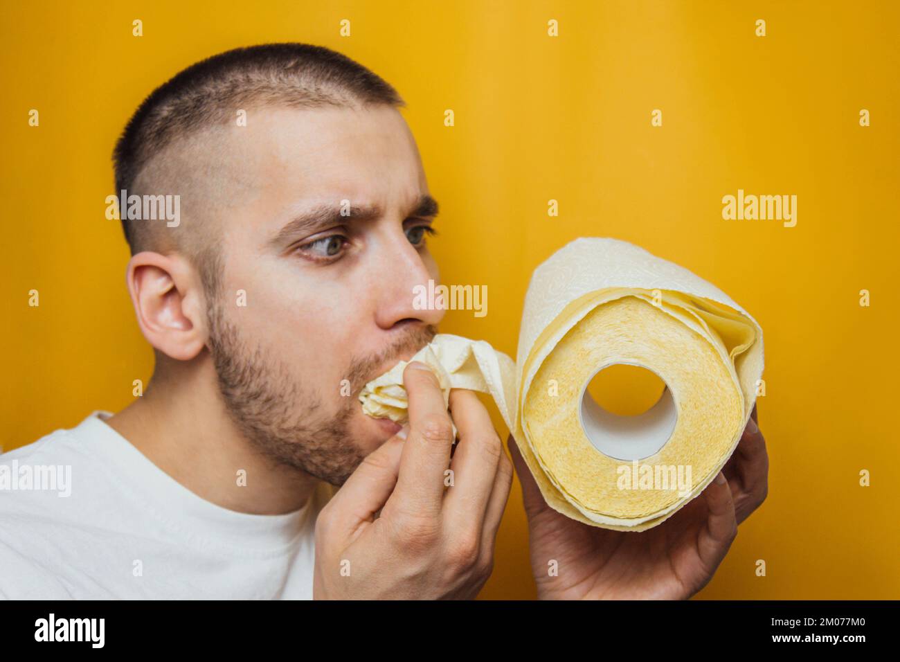 The guy eagerly eats toilet paper. The concept of overbought toilet