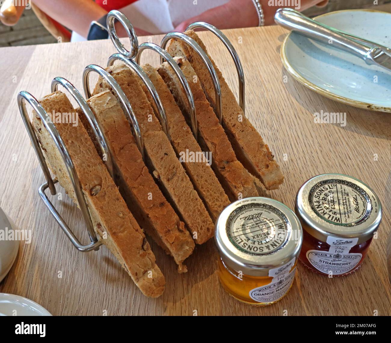 Rack of breakfast toast, with Tiptree jars of orange marmalade and strawberry jam Stock Photo