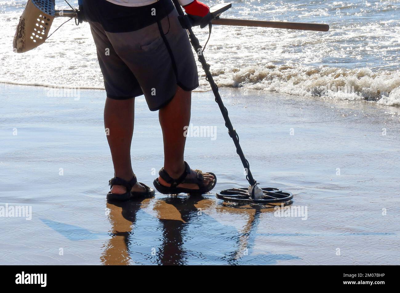 https://c8.alamy.com/comp/2M07BHP/a-man-with-a-metal-detector-on-a-sandy-sea-beach-2M07BHP.jpg